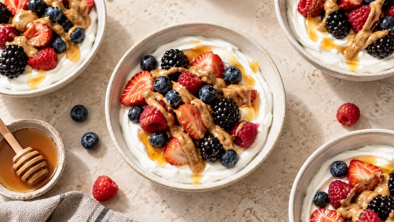 Greek yogurt topped with mixed berries, almond butter, and honey