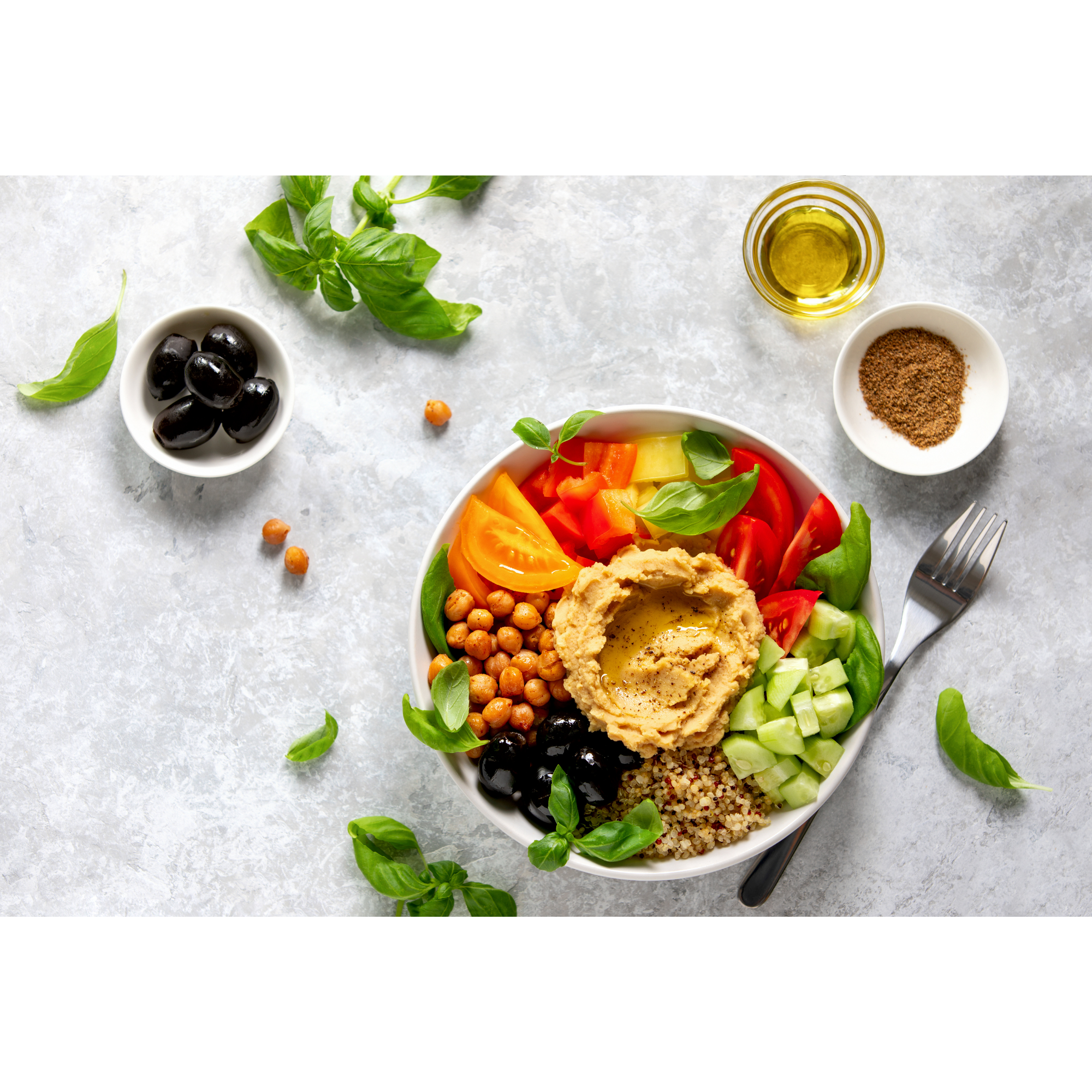 Mediterranean chickpea bowl with hummus, quinoa, tomatoes, cucumber, and olives